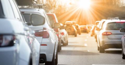 Auto's in de file met een ondergaande zon